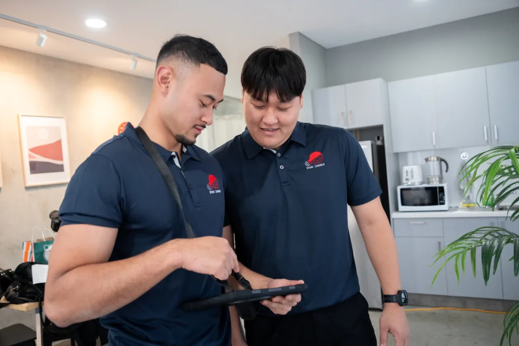 Spark Chamber electricians reviewing a job on a tablet