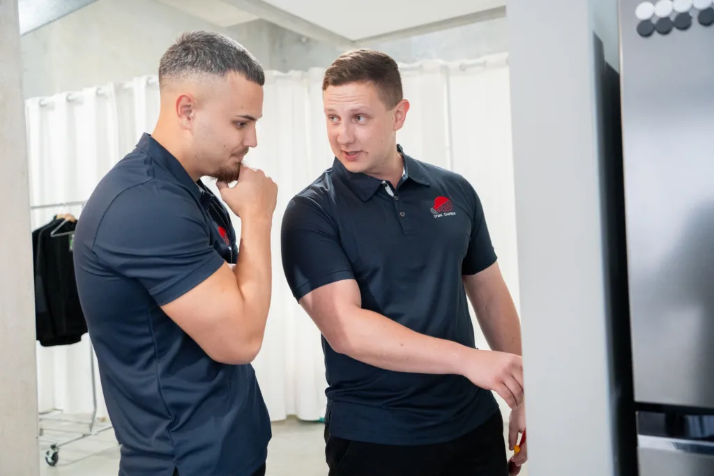 Two Spark Chamber electricians planning a job