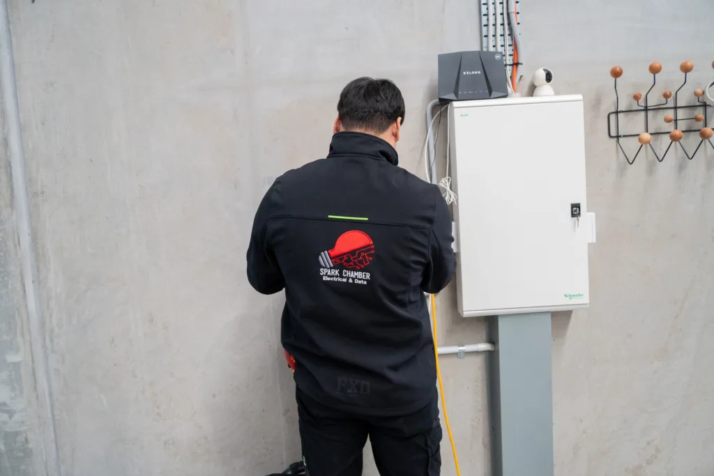 Spark Chamber electrician working at a wall-mounted enclosure